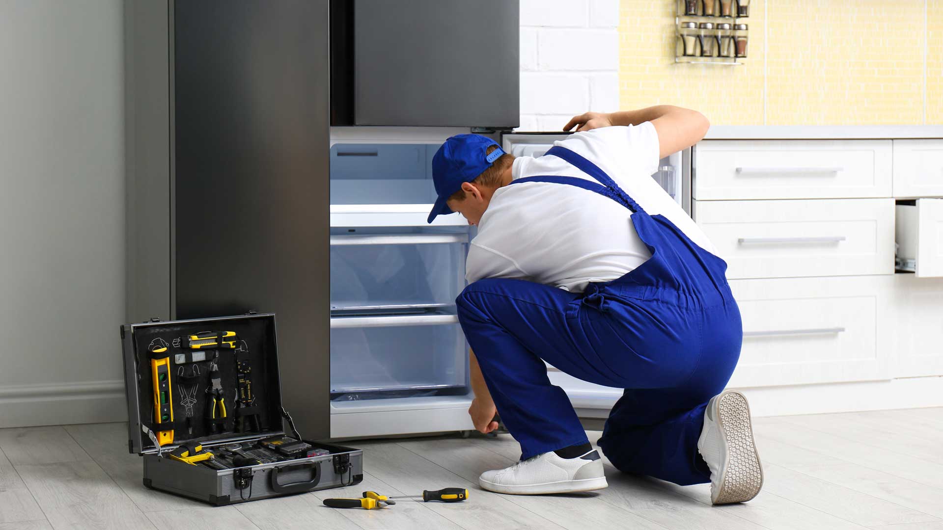 Repairman repairing the freezer drawer on a refrigerator
