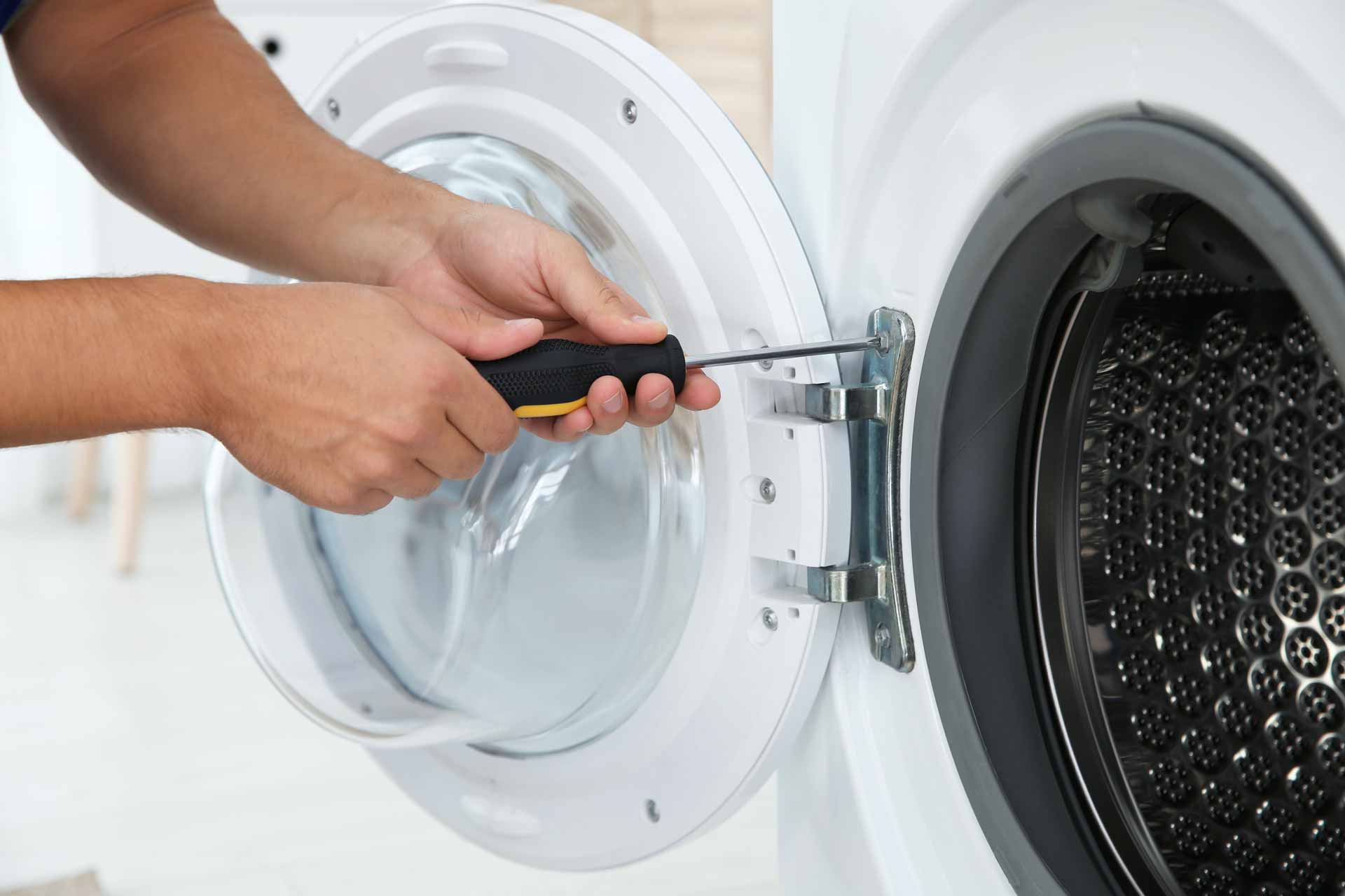 Close-up shot of technician fixing a clothes dryer