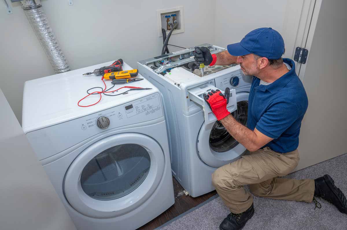 Appliance repair technician repairing a washing machine